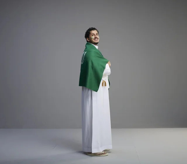 شاب سعودي يرتدي العلم السعودي في الاستوديو