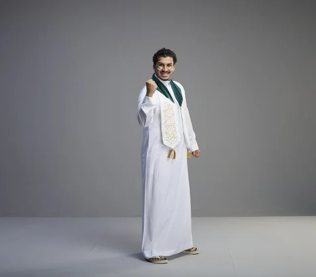 شاب سعودي بملابس اليوم الوطني يحتفل في الاستوديو