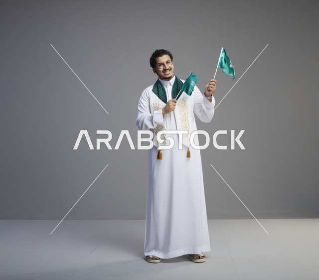 شاب سعودي يحمل الأعلام في احتفالات اليوم الوطني