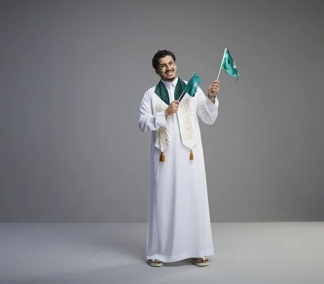 شاب سعودي يحمل الأعلام في احتفالات اليوم الوطني