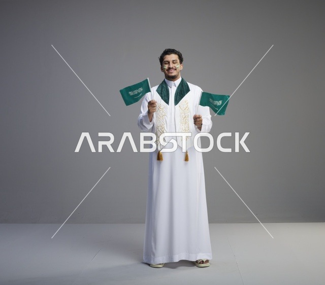 شاب سعودي يحمل الأعلام في احتفال اليوم الوطني