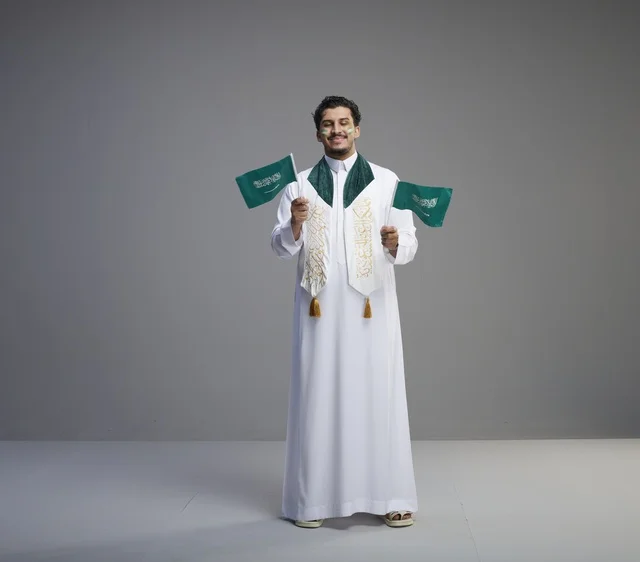 شاب سعودي يحمل الأعلام في احتفال اليوم الوطني