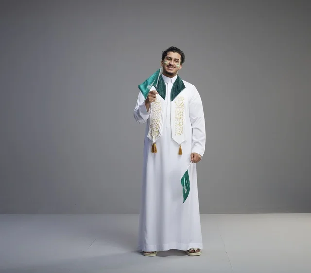 شاب سعودي يحمل الأعلام الوطنية في استوديو