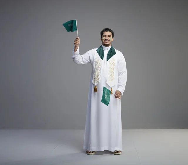 Saudi Man in Traditional Thobe Holding National Flags