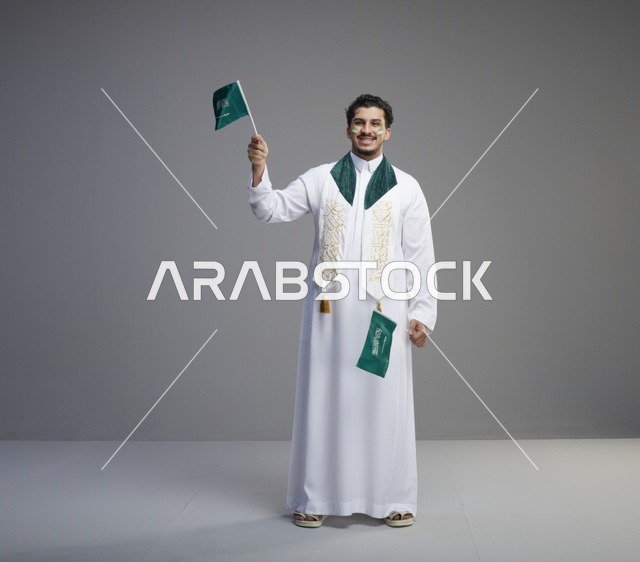 شاب سعودي يحمل العلم الوطني في احتفال يوم التأسيس