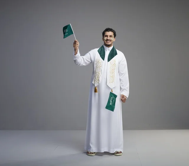 شاب سعودي يحمل العلم الوطني في احتفال يوم التأسيس