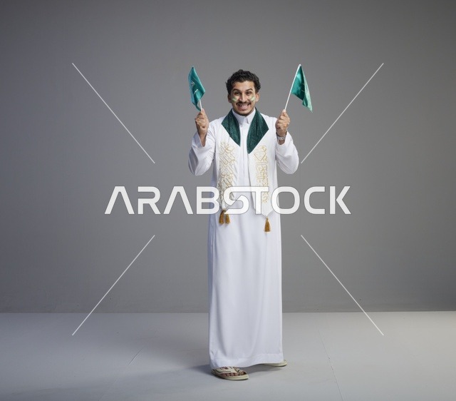 شاب سعودي يحمل الأعلام في احتفال اليوم الوطني
