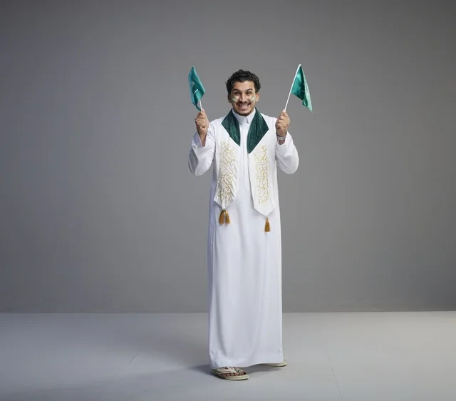 شاب سعودي يحمل الأعلام في احتفال اليوم الوطني