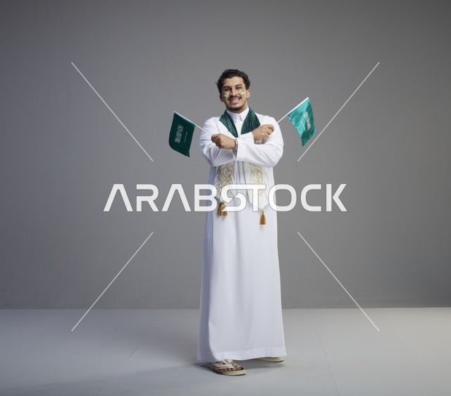 شاب سعودي يحمل الأعلام في احتفال اليوم الوطني