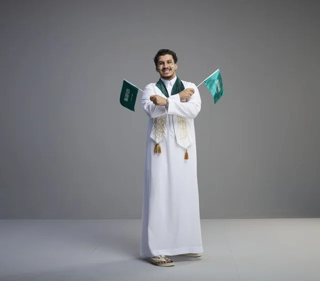 شاب سعودي يحمل الأعلام في احتفال اليوم الوطني