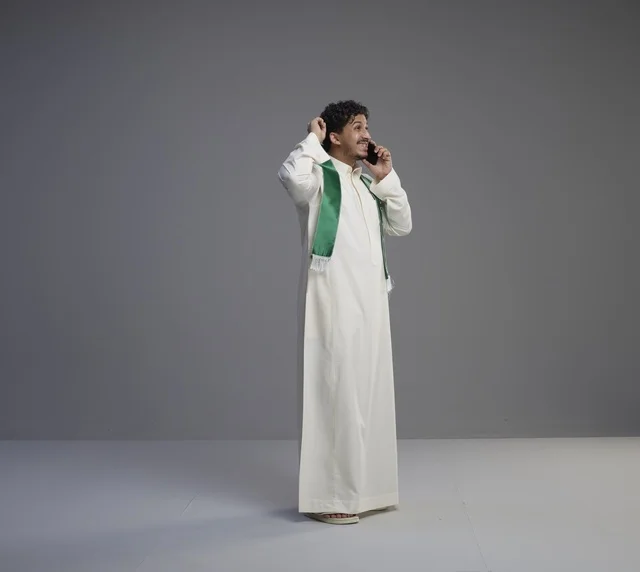 Saudi Man in Thobe Talking on Smartphone with Green Scarf