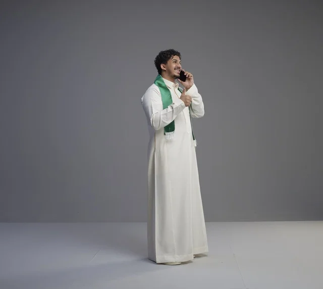 Saudi Man with Smartphone and Thumbs Up Gesture Studio