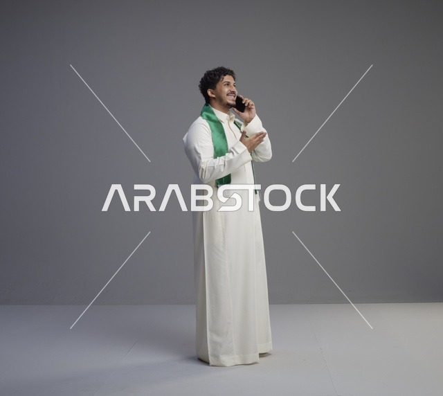 شاب سعودي بالثوب يتحدث بالهاتف في الاستوديو