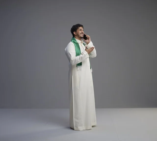شاب سعودي بالثوب يتحدث بالهاتف في الاستوديو