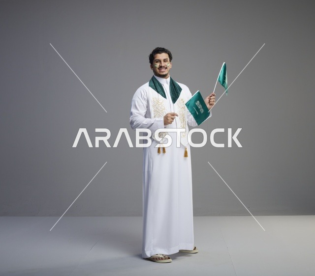 شاب سعودي يحمل الأعلام السعودية في استوديو