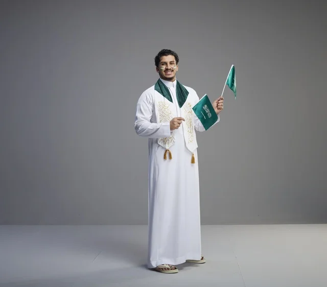 شاب سعودي يحمل الأعلام السعودية في استوديو
