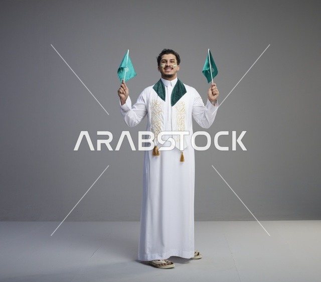 شاب سعودي يحمل الأعلام في احتفالات اليوم الوطني