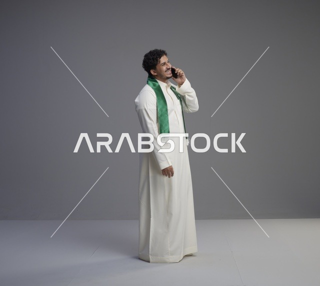 شاب سعودي بالثوب يتحدث عبر الهاتف الذكي
