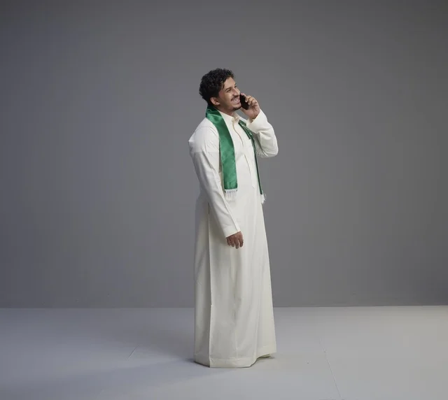 Saudi Man in Thobe Talking on Smartphone