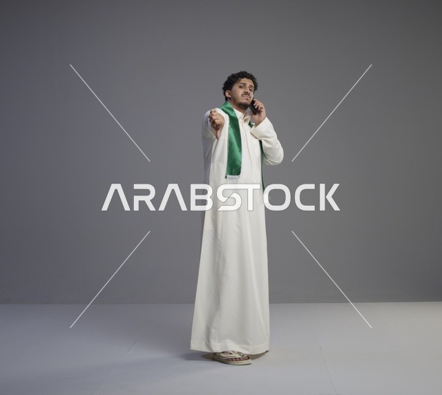 شاب سعودي يتحدث بالهاتف الذكي مع إشارة الرفض