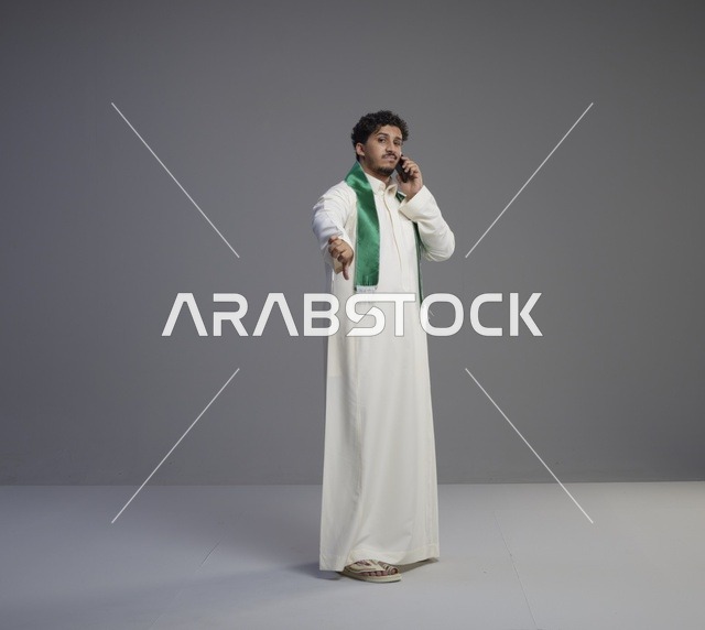 شاب سعودي يتحدث بالهاتف مع إشارة عدم الإعجاب