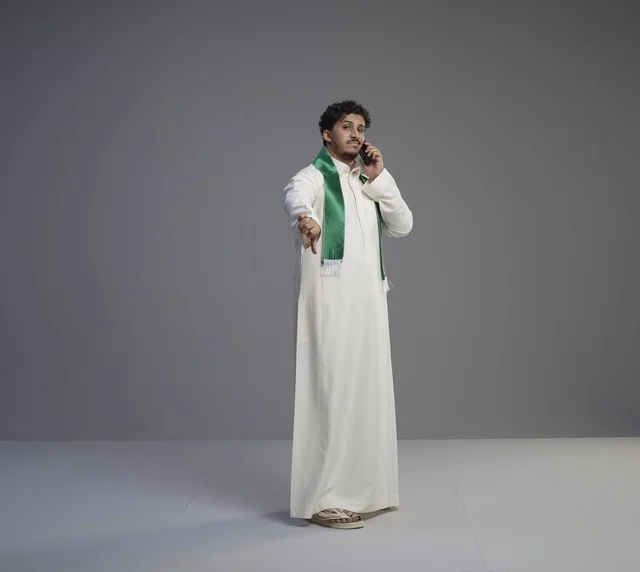 Saudi Man Talking on Smartphone with Thumbs Down Gesture