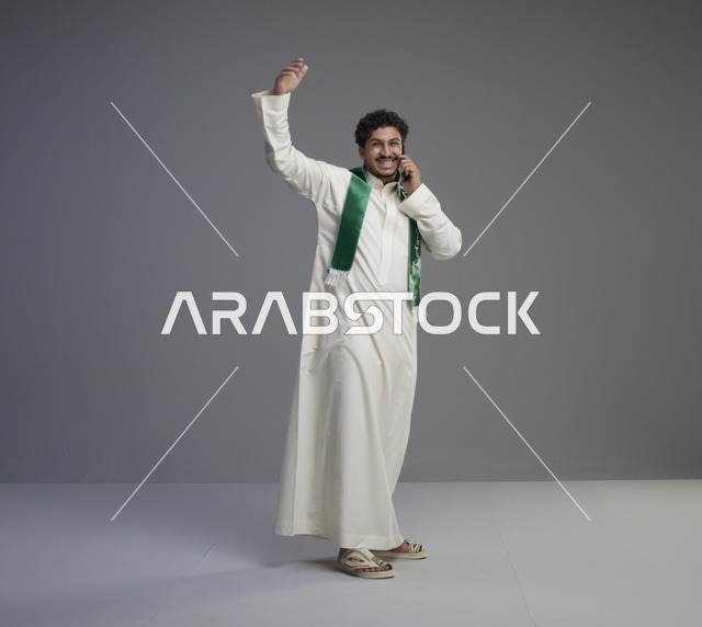 شاب سعودي يتحدث بالهاتف مع وشاح أخضر