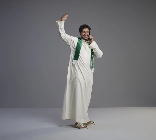شاب سعودي يتحدث بالهاتف مع وشاح أخضر