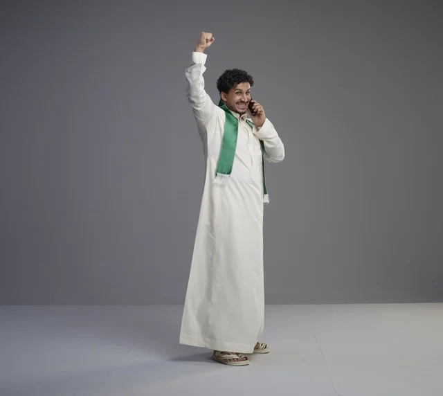 شاب سعودي يحتفل أثناء التحدث بالهاتف الذكي في الاستوديو