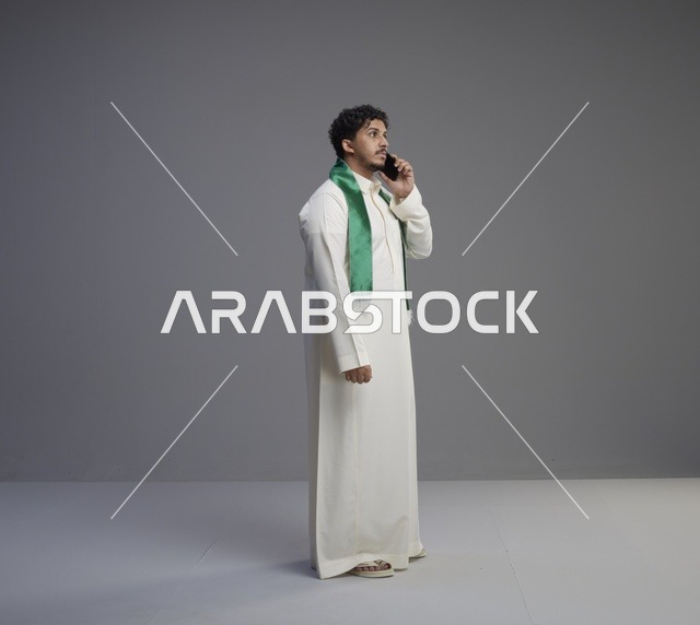 شاب سعودي بالثوب يتحدث عبر الهاتف الذكي