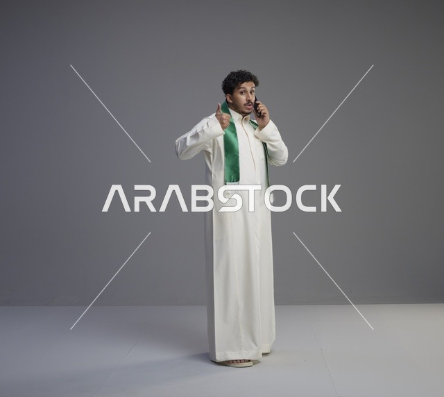 شاب سعودي بالثوب يتحدث بالهاتف الذكي في الاستوديو