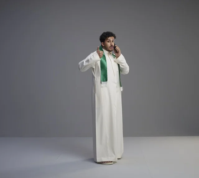 Saudi Man in Thobe Talking on Smartphone Studio Shot