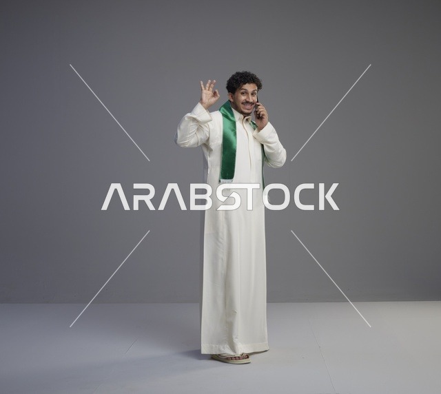 شاب سعودي بالثوب يتحدث بالهاتف الذكي في الاستوديو