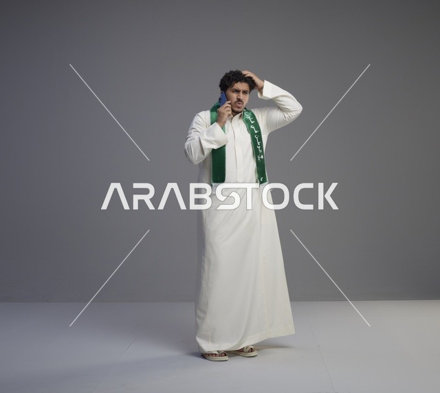 شاب سعودي بالثوب يتحدث بالهاتف الذكي في استوديو
