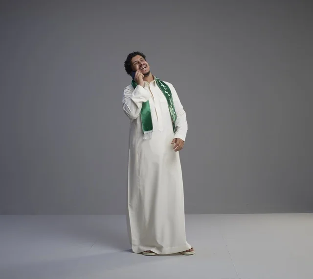 Saudi Man in Thobe Talking on Smartphone Studio Shot