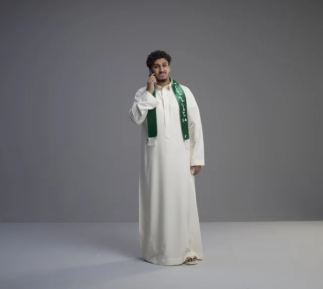 Saudi Man in Thobe Talking on Smartphone Studio Shot