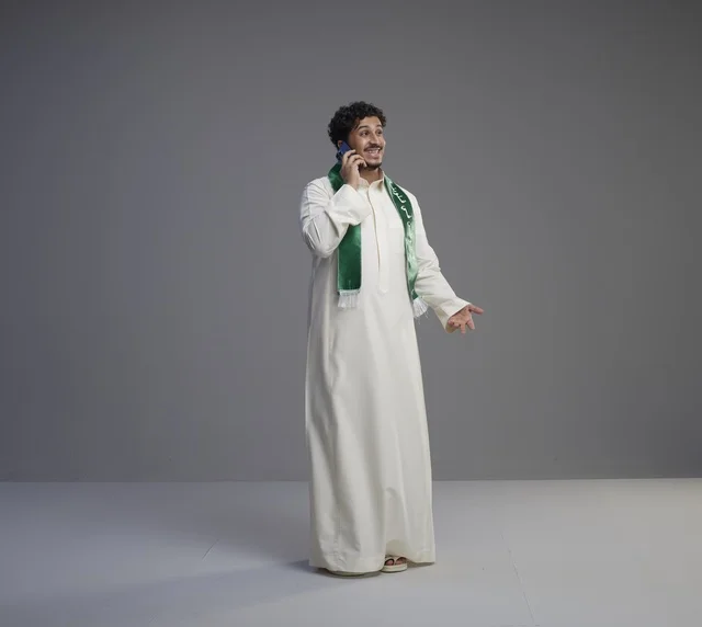 Saudi Man in Thobe Talking on Smartphone Studio