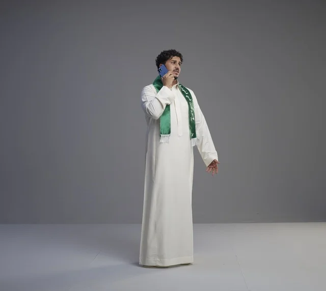 شاب سعودي بالثوب يتحدث عبر الهاتف في الاستوديو