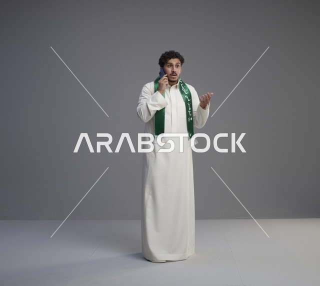 شاب سعودي يتحدث عبر الهاتف الذكي بالزي التقليدي