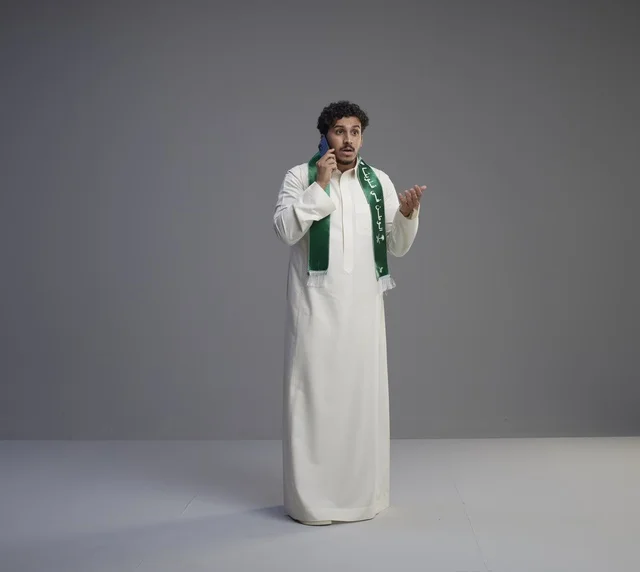 Saudi Man Talking on Smartphone in Traditional Thobe