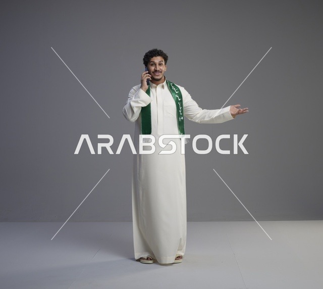 شاب سعودي بالثوب يتحدث بالهاتف الذكي في الاستوديو