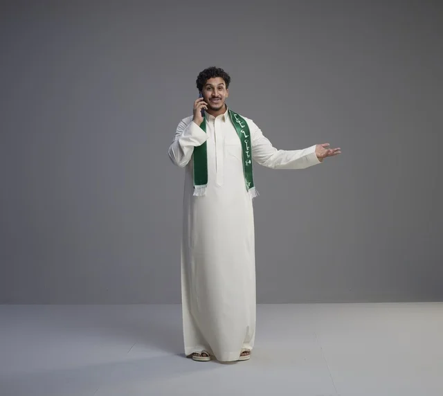 Saudi Man in Thobe Talking on Smartphone Studio Shot