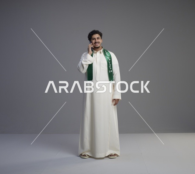 شاب سعودي بالثوب الوطني يتحدث عبر الهاتف في الاستوديو