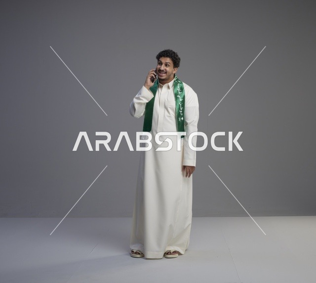 شاب سعودي بالثوب يتحدث عبر الهاتف الذكي في الاستوديو