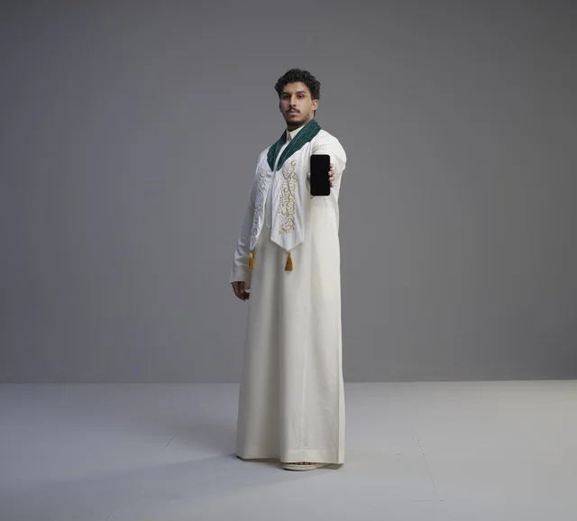 Saudi Man in Traditional Thobe Holding Smartphone Screen