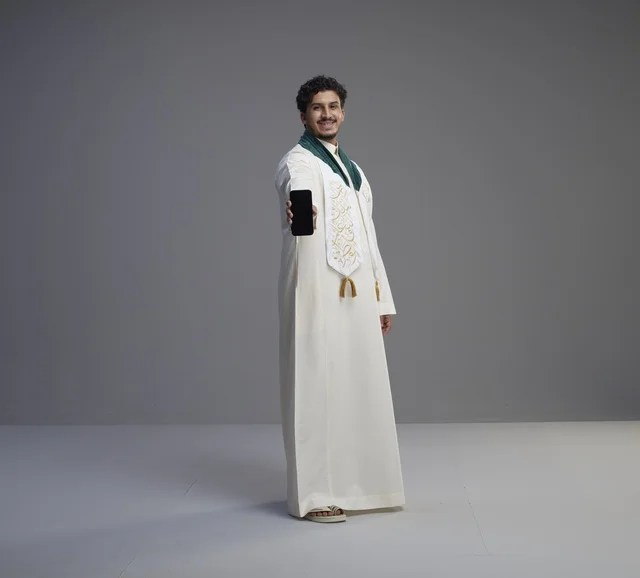 Saudi Man in Thobe Holding Smartphone in Studio