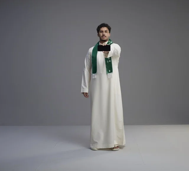 شاب سعودي يحمل هاتف ذكي بشاشة فارغة