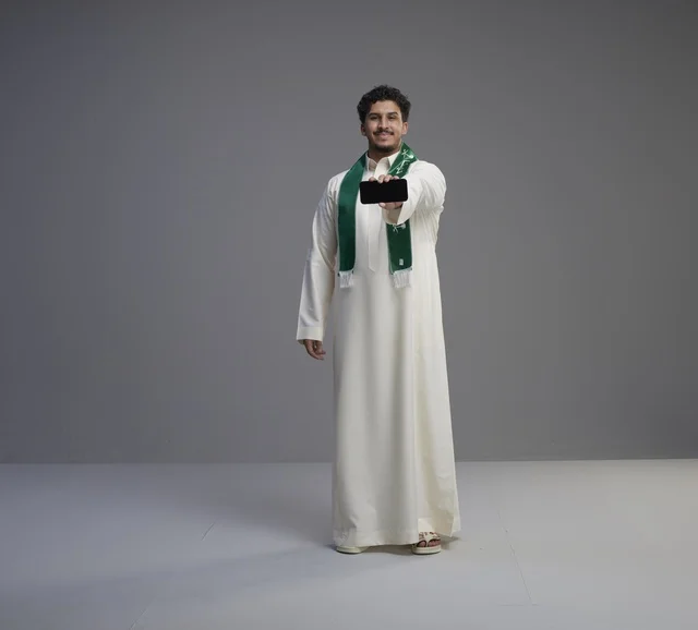 Saudi Man Holding Smartphone with Blank Screen
