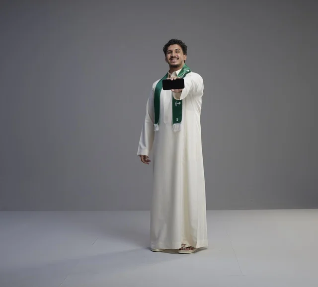 Saudi Man Holding Smartphone Screen in Studio