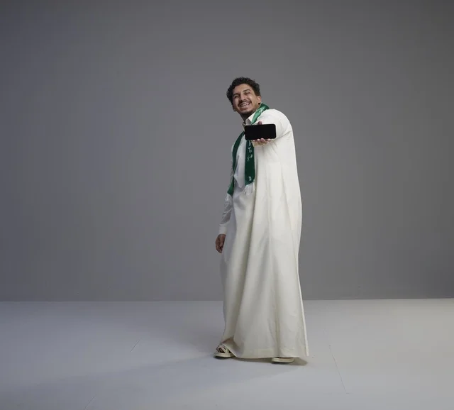 Saudi Man Holding Smartphone Screen in Studio